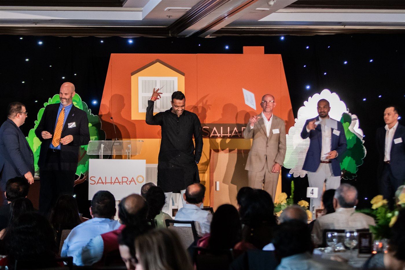 Adrian Saint on stage with corporate executive volunteers